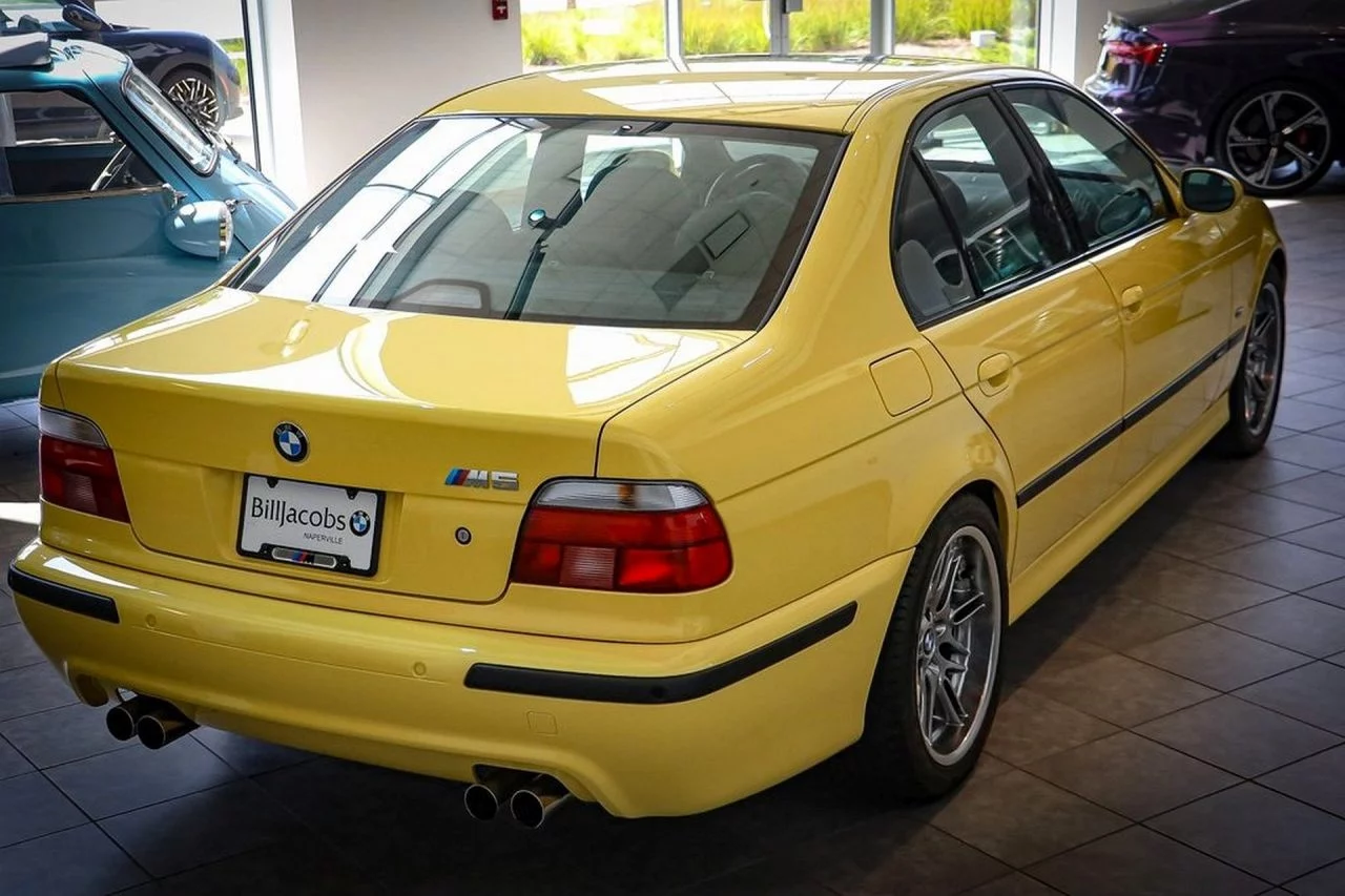 Vista trasera y lateral del icónico BMW M5 E39 en color amarillo.