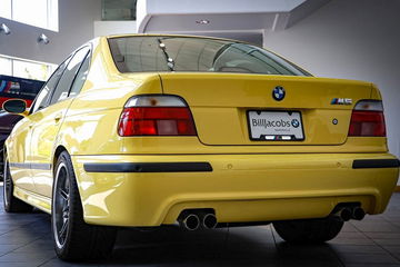 BMW M5 E39 en amarillo, vista trasera que irradia deportividad y potencia.