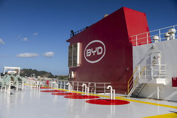 Vista lateral de un buque de carga con logo de BYD en el área de la cubierta.