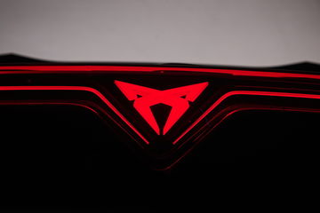 Vista parcial del distintivo logo de CUPRA iluminado en el interior.