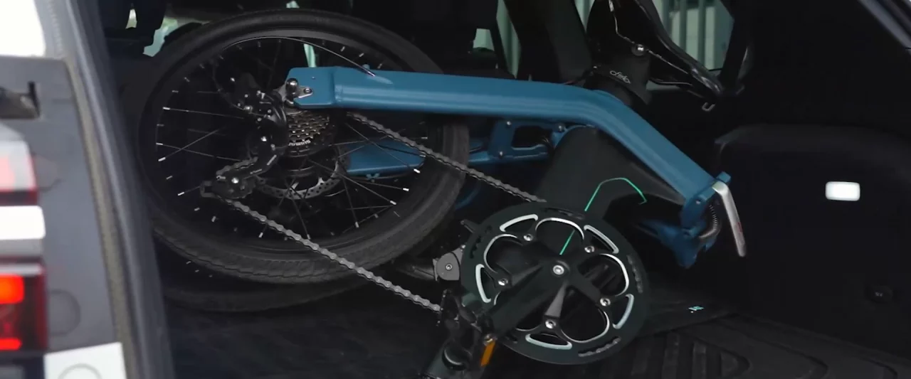 Bicicleta eléctrica Fiido D11 plegada cabiendo perfectamente en un maletero de coche.