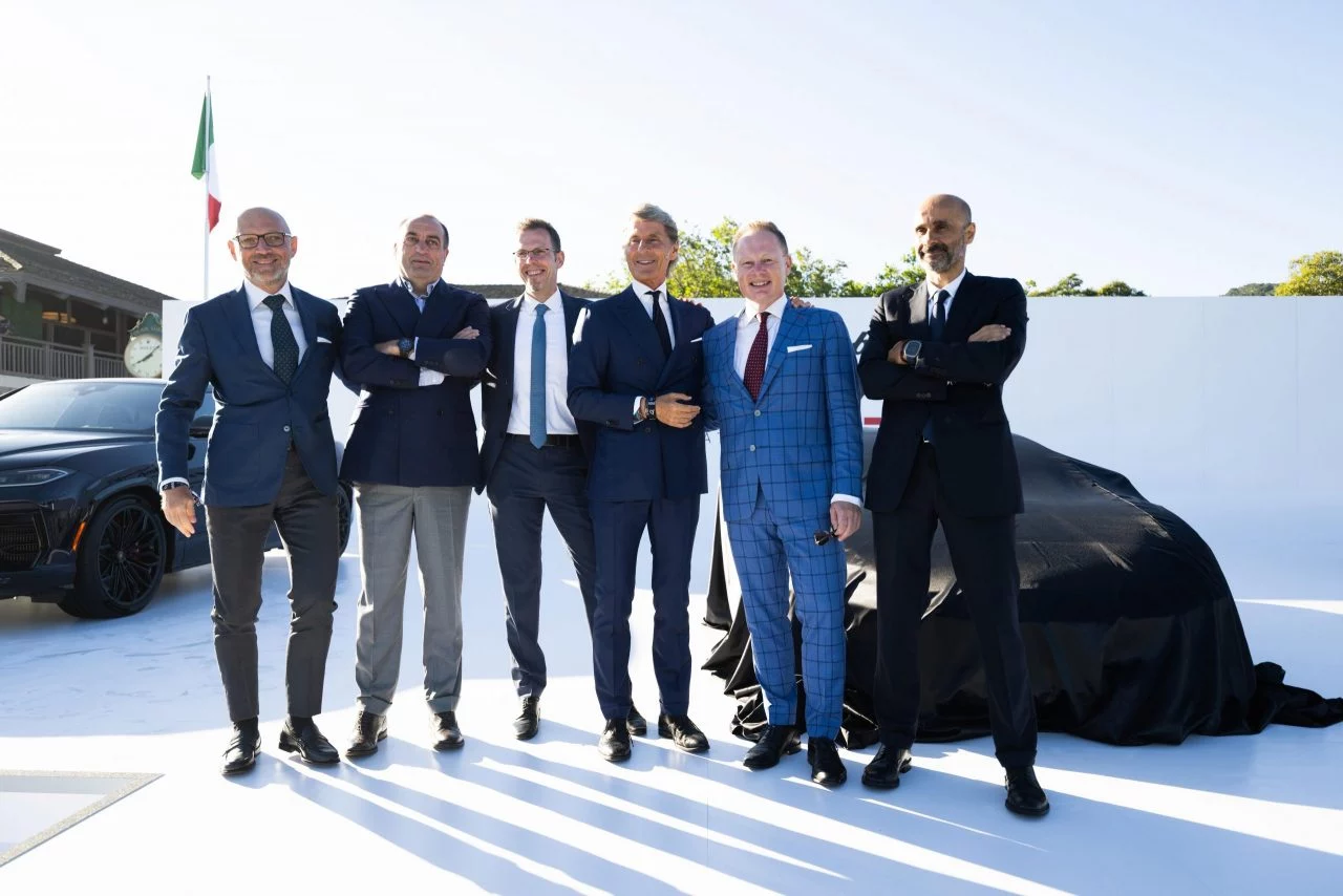 Directivos de Lamborghini junto a un modelo cubierto en Pebble Beach.