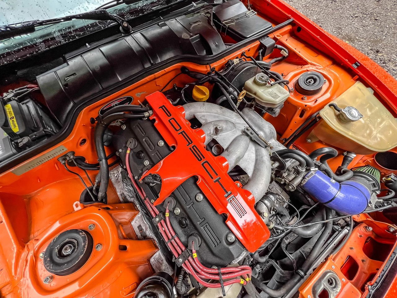 Vista del motor de un Porsche potenciado, con acabados en fibra de carbono.