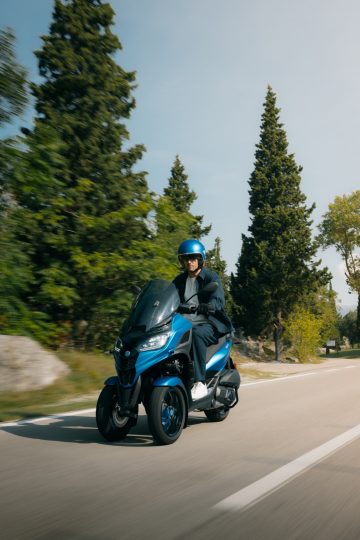 Piaggio MP3 310 en movimiento, destacando su diseño de 3 ruedas.