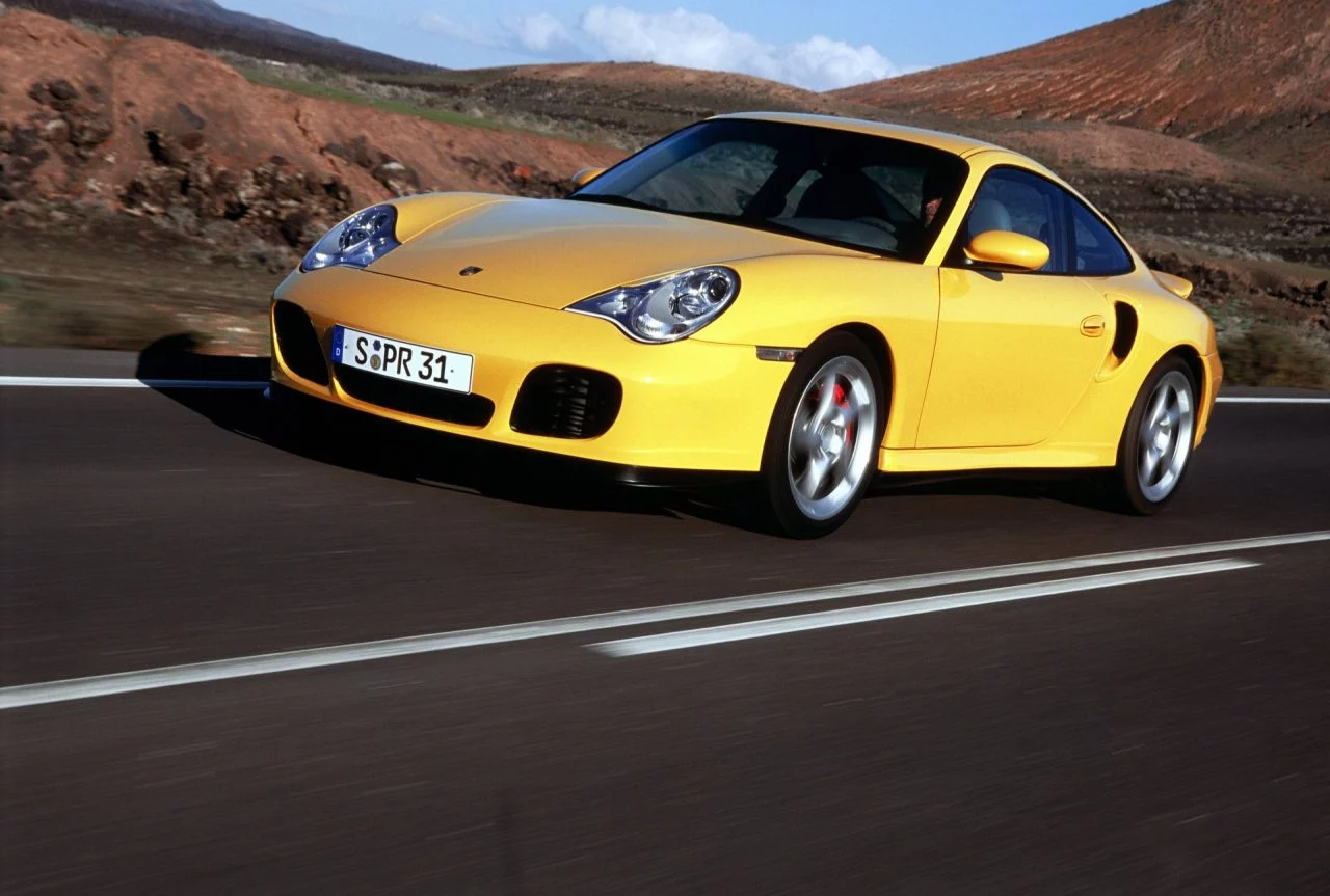 Porsche amarillo en carretera, ilustrando su diseño aerodinámico y elegante.