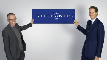 Carlos Tavares, CEO de Stellantis, sosteniendo un cartel con el logo de la compañía.