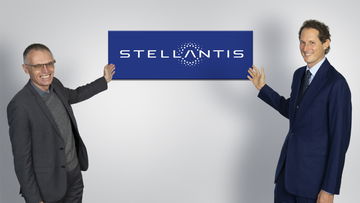 Carlos Tavares, CEO de Stellantis, sosteniendo un cartel con el logo de la compañía.