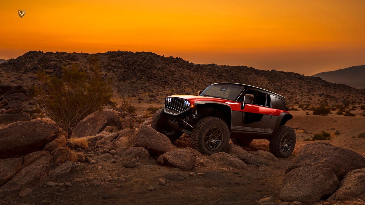 Vista lateral de un 4x4 compacto dominando terreno escarpado al atardecer