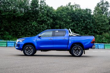 Vista lateral de la Toyota Hilux híbrida mostrando su robustez y diseño adaptado al terreno todoterreno.