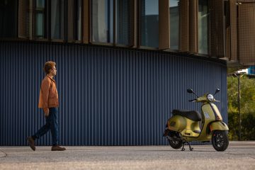 Vista lateral de la Vespa GTS 2024 aparcada en la ciudad, diseño clásico renovado.