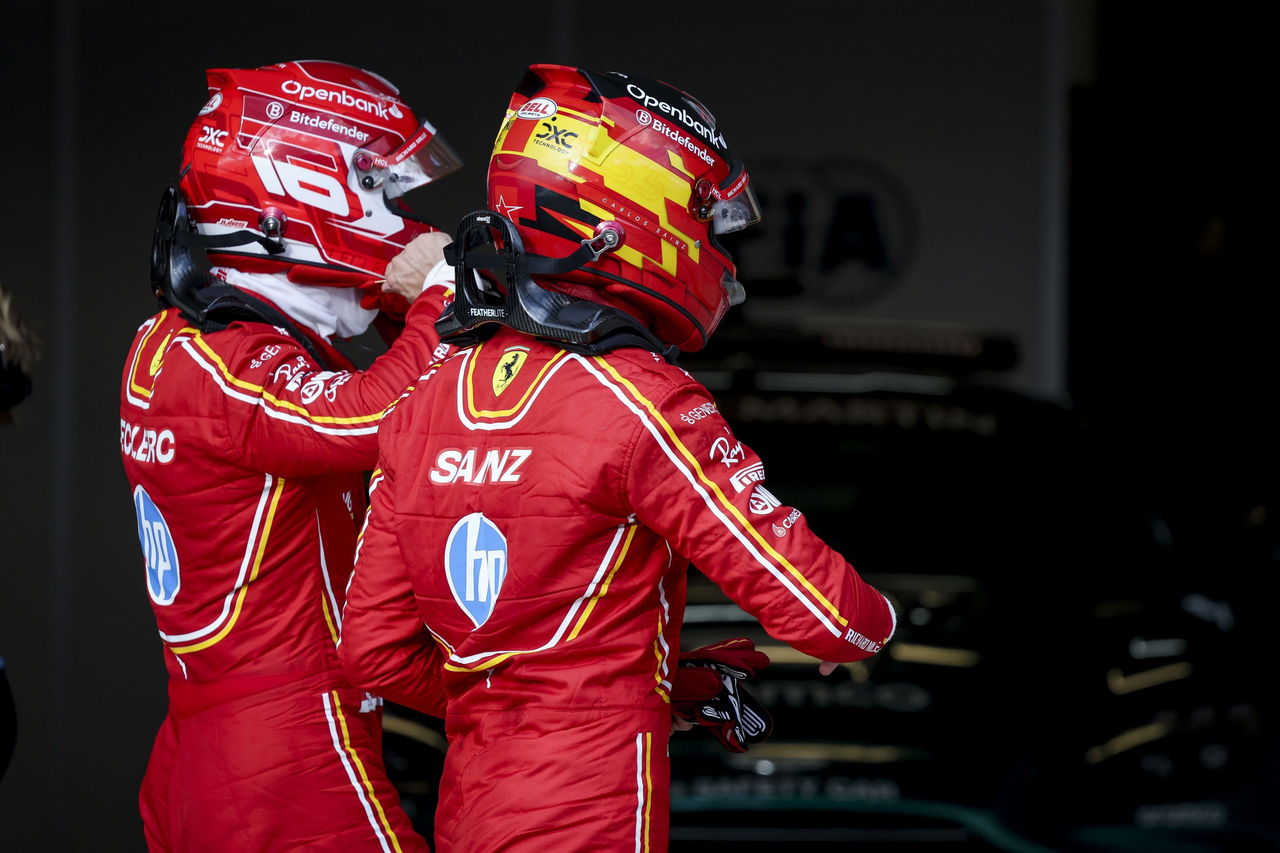 Carlos Sainz y compañero equipo celebran éxito en el box de Ferrari.