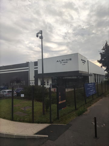 Vista lateral del edificio del equipo de F1 Alpine en un día nublado.