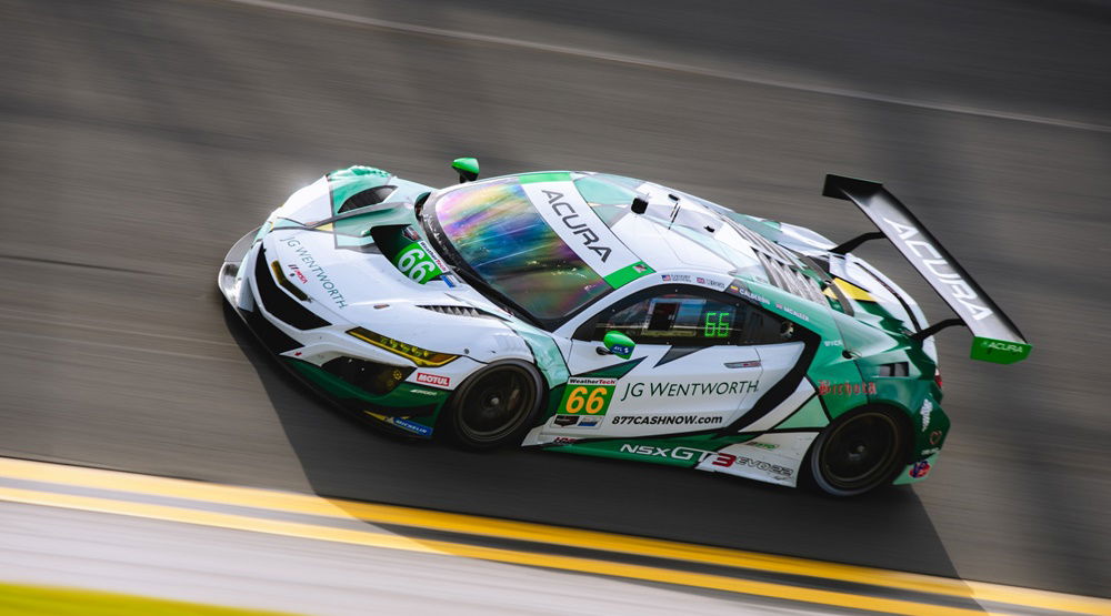 El Acura NSX GT3 en acción, mostrando su aerodinámica y diseño lateral.