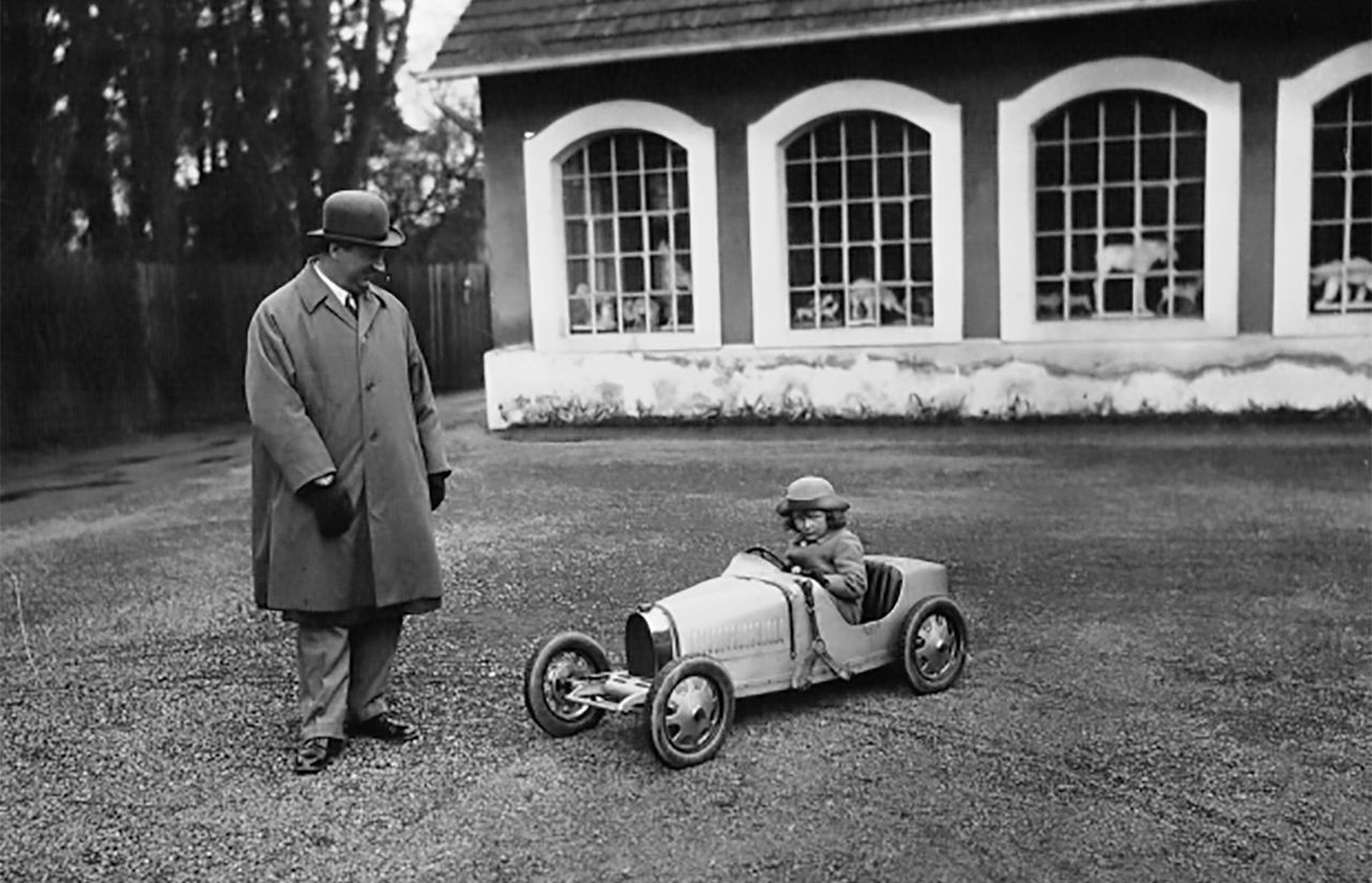 Ettore Bugatti junto a un clásico de su creación en formato reducido.