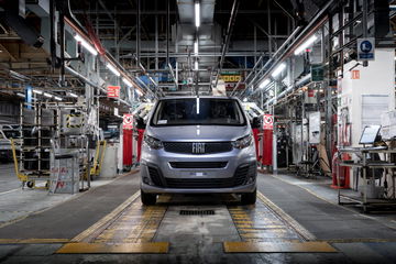 Fiat Scudo emergiendo de la línea de montaje con faros y parrilla visibles.