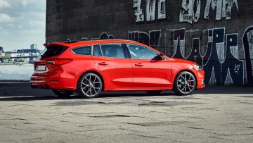 Vista lateral del Ford Focus ST Sportbreak en tono rojo vibrante, resalta su diseño deportivo.