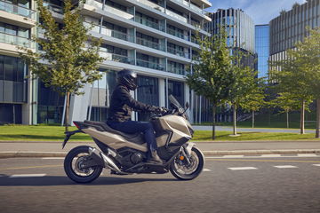 Vista lateral del Honda Forza 750 en acción, destacando su diseño aerodinámico.