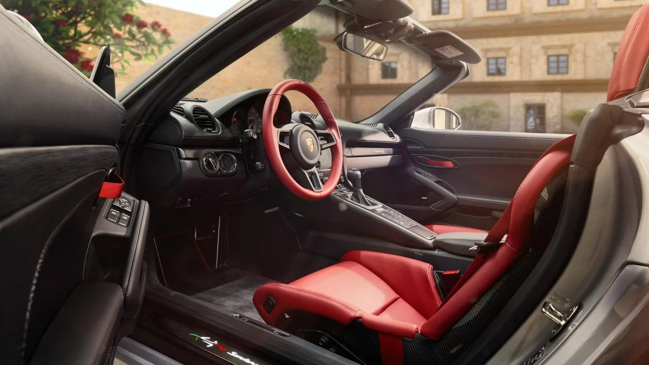 Vista lateral interior de un Porsche con asientos rojos, acabado premium.