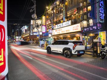 KIA EV3 posando dinámicamente en un vivo entorno urbano nocturno.