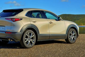 Vista lateral del Mazda CX-30 destacando su diseño aerodinámico y líneas modernas.