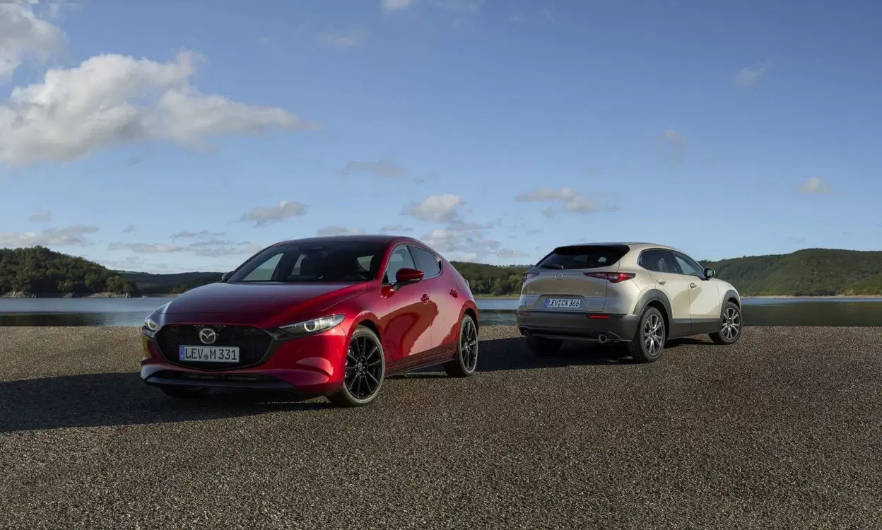 Vista del Mazda3 y CX-30 en paisaje natural, destacando diseño y acabados.