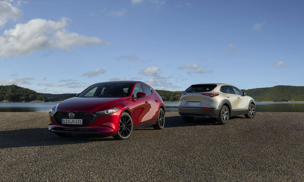 Vista del Mazda3 y CX-30 en paisaje natural, destacando diseño y acabados.