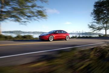 Vista dinámica del Model 3 en carretera evidenciando su elegante diseño lateral.