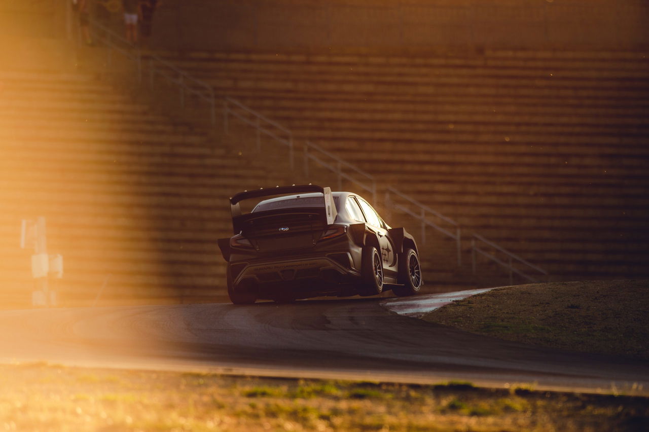 Bólido WRC captado en dinámica curva al atardecer, destaca aerodinámica