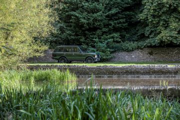 Range Rover Classic renovado con tecnología actual, visión lateral entre naturaleza.