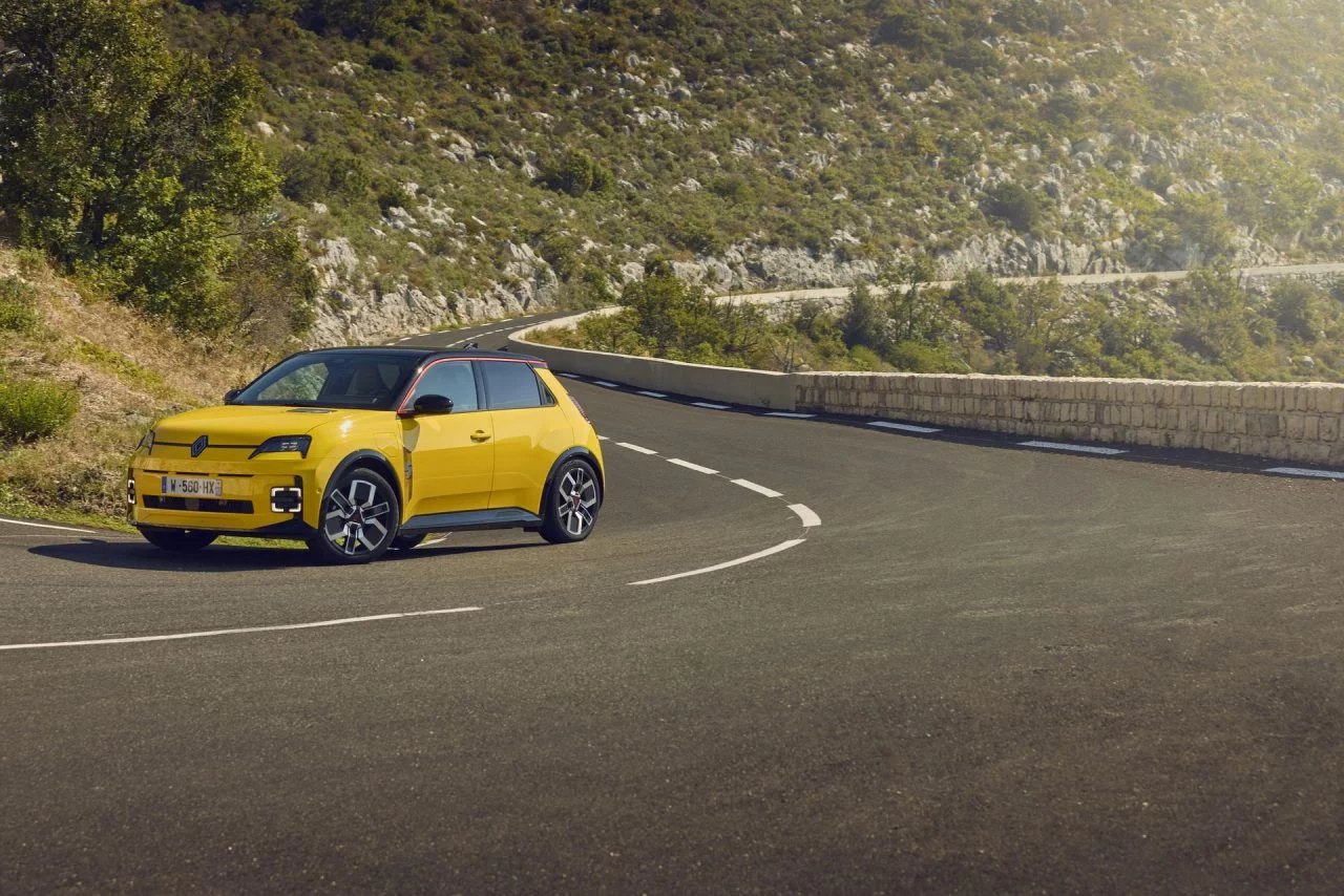 Vista dinámica del Renault 5 en carretera, destacando su diseño retro-moderno.