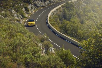 Vista lateral del Renault 5 en movimiento, destacando su diseño icónico y moderno