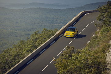 Vista aérea del Renault 5 eléctrico tomando una curva con dinamismo.