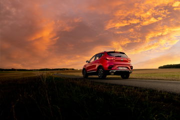 El MG ZS muestra su línea trasera y lateral con crepúsculo de fondo, destacando su diseño asequible y moderno.