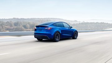 Vista dinámica del Tesla Model Y mostrando su línea trasera y lateral en movimiento.