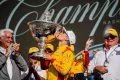 Álex Palou celebrando su tricampeonato en IndyCar con el trofeo.