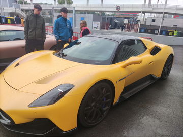 Un impresionante modelo amarillo en una pista, mostrando su diseño aerodinámico.