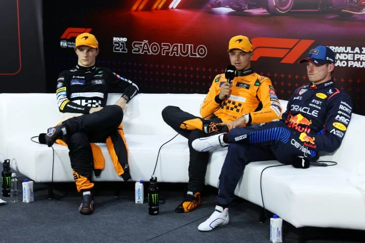 Tres pilotos de F1 durante una conferencia de prensa, con Verstappen destacando