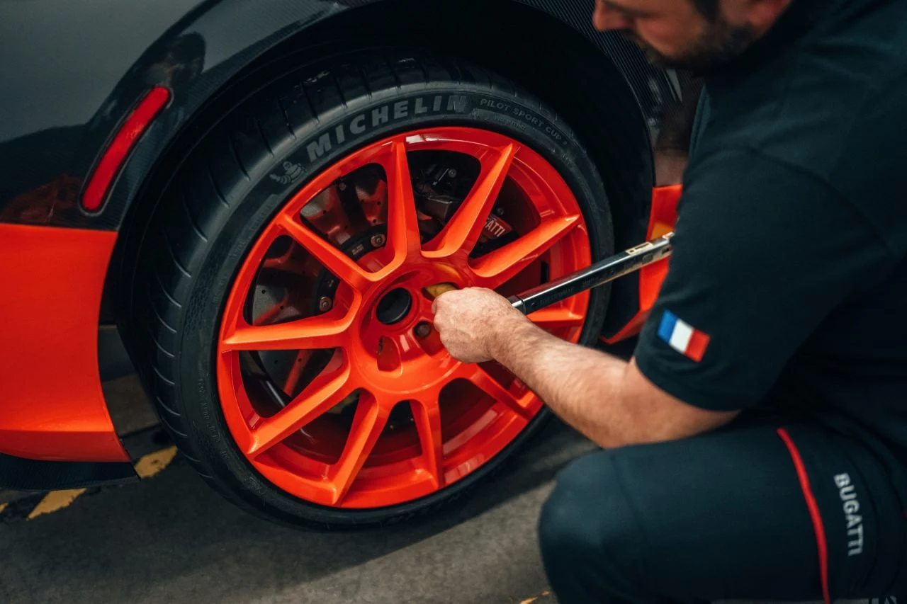 Técnico ajustando la llanta del impresionante Bugatti Mistral.