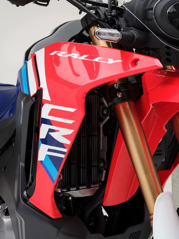 Close-up de la Honda CRF300 Rally, destacando su diseño ergonómico y colores vibrantes.