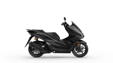 El scooter Honda PCX 125 se muestra en su perfil mejorado, manteniendo su fiabilidad legendaria.