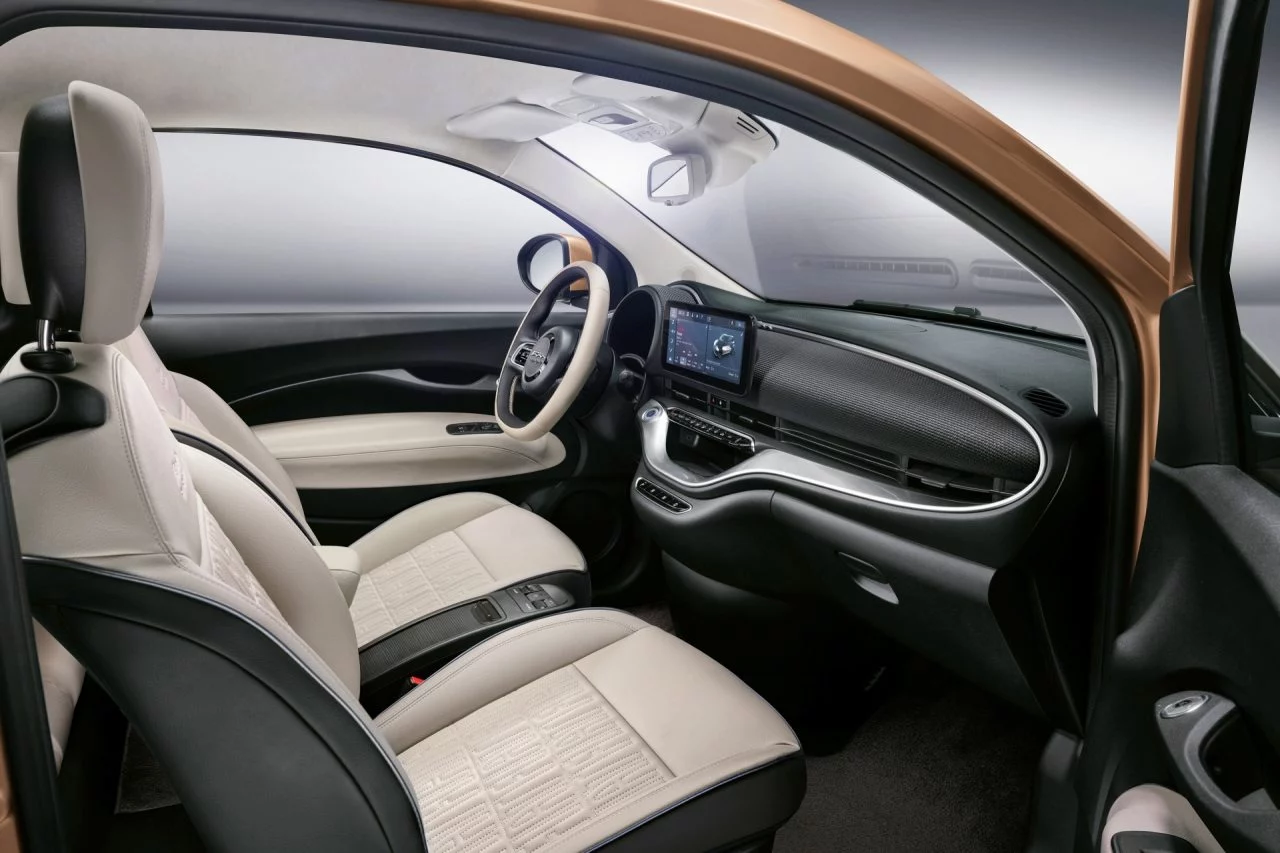 Interior del Fiat 500 eléctrico con acabados elegantes y tecnología moderna.