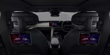 Vista interior con pantallas traseras, diseño moderno y espacio optimizado.