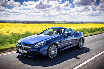 Vista dinámica del Mercedes-Benz SLC 180 en carretera, ideal para viajes.