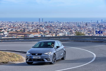 El SEAT Ibiza se muestra en acción, destacando su diseño dinámico en un paisaje urbano.