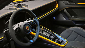 Vista del interior del Porsche 911 Dakar, con detalles en amarillo que destacan su diseño moderno