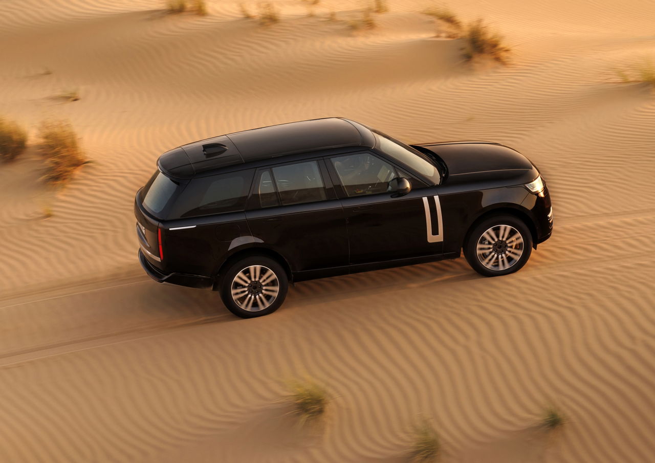 Vista lateral del Range Rover eléctrico en un entorno desértico.