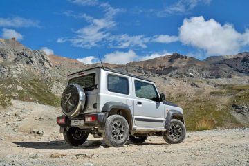 Vista lateral del robusto Suzuki Jimny en terreno pedregoso, mostrando su capacidad todoterreno.