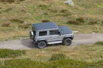 Vista lateral del Suzuki Jimny en su hábitat natural, demostrando su capacidad todoterreno.