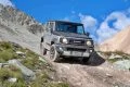 Vista del Suzuki Jimny en acción por montaña, dominando el terreno con su diseño robusto.