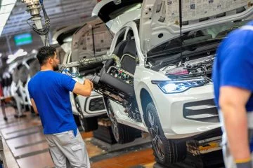 Trabajadores ensamblando vehículos en la fábrica de Volkswagen.